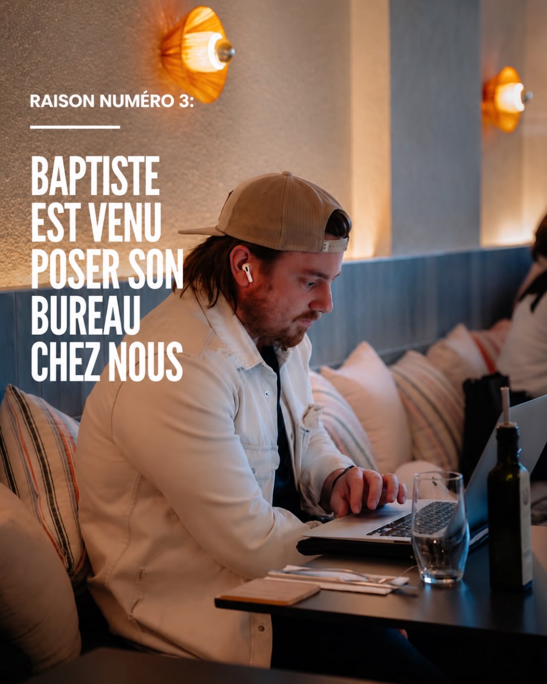 Baptiste travaillant sur son ordinateur, installé dans la banquette